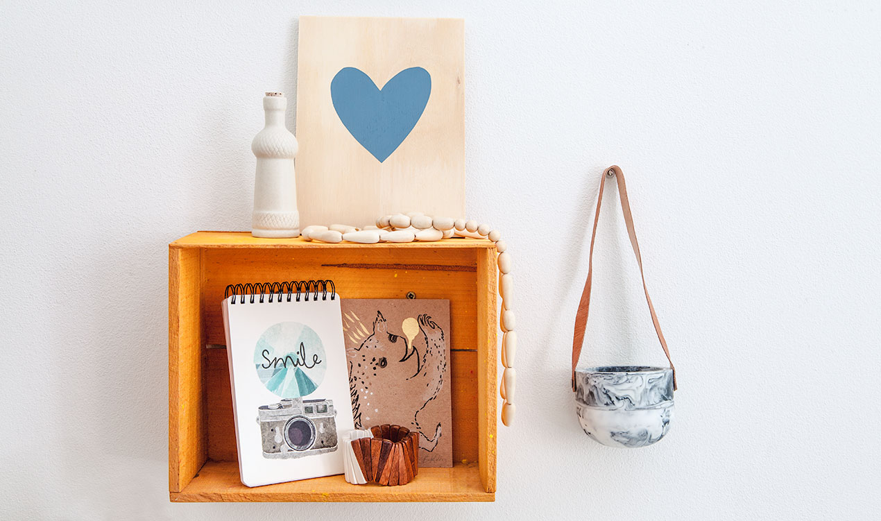 Indie styled product selection with ceramic bottle, artworks, notebook, wooden bracelet, necklace and hanging resin planter.